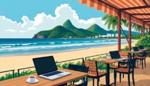Beachside cafe with laptops, coffee, and a view of mountains and ocean